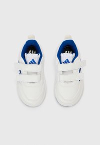 Valkoiset urheilukengät sinisin yksityiskohdin, joissa on kaksi tarranauhakiinnitystä, teksturoitu materiaali ja pyöreä kärki.