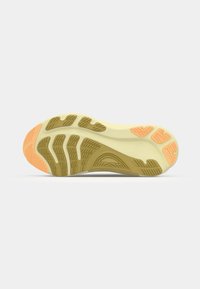 Sole of a sneaker featuring a grooved yellow-green design with an orange accent at the toe and textured patterns for grip.