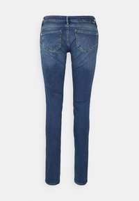 Jeans denim w ciemnym niebieskim kolorze, Slim fit, z klasycznym pięciopocketowym wzornictwem. Posiadają lekki efekt przetarcia i unikalne detale w przeszyciach tylnej kieszeni.