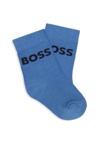 Chaussettes en coton bleu avec des poignets côtelés, portant "BOSS" en lettres noires en gras sur le côté. Texture lisse et longueur de chaussette classique.