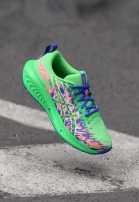Πράσινο αθλητικό παπούτσι με υφή στην επάνω πλευρά, διαθέτει μπλε λεπτομέρειες και πολύχρωμο μοτίβο. Ελαφρύ σχέδιο με μαξιλαρωμένο κολάρο και κορδόνια.