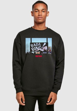 Black cotton sweatshirt featuring a colorful "BADA BING" graphic and character design. Ribbed cuffs and hem, relaxed fit.
