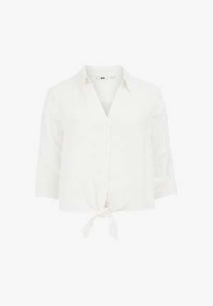 Balta īsā krekla, pogu aizdare un ar saitītes priekšpusi. Izgatavots no mīksta, teksturēta auduma un ar trīs ceturtdaļu piedurknēm.