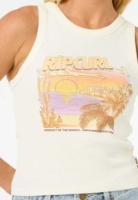 Top a canotta bianco a righe con una grafica di un tramonto colorato, alberi di palma e il testo "RIP CURL" in un font retro.
