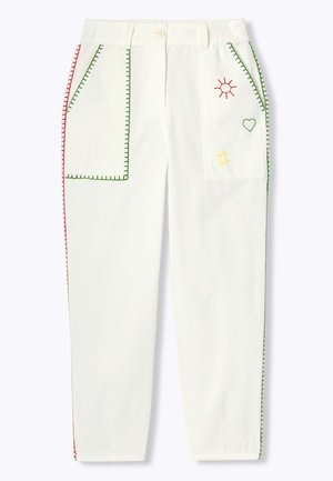 Pantalon blanc avec de grandes poches avant bordées de coutures vertes et rouges, avec broderies de soleil, cœur et quadrillage sur la poche droite.