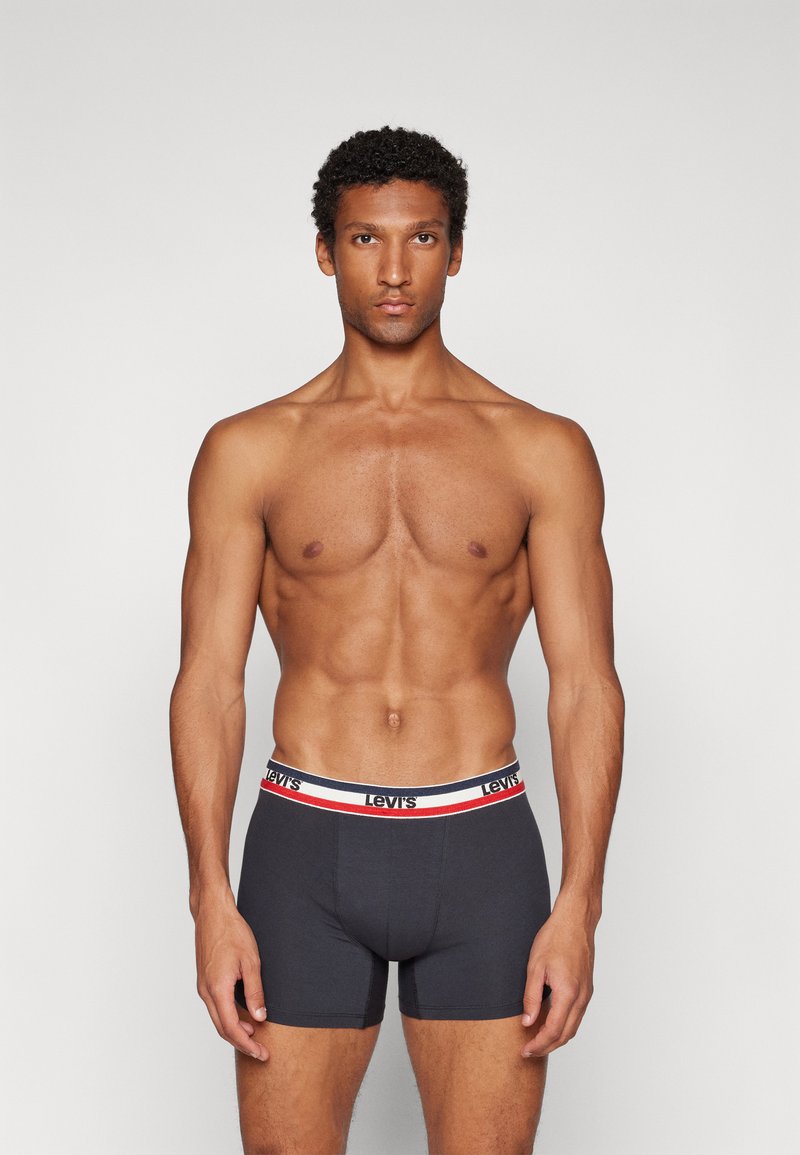 Heren donkergrijze boxershorts met een zachte tailleband voorzien van een rood-witte streep en een prominent weergegeven logo. Glad materiaal en een aansluitend ontwerp.