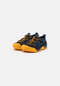 Blue and black athletic shoes with a breathable mesh upper, yellow rubber sole, and elastic laces. Features reinforced toe and heel.