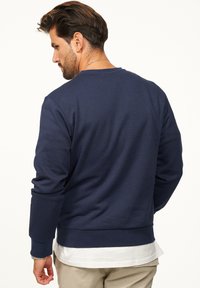 Navy blue, long-sleeve sweatshirt with ribbed cuffs and hem. Soft fabric, classic crew neck design, and minimalistic style.