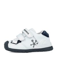 Zapatillas blancas para niños con correas ajustables de Velcro, acentos negros, suela de goma texturizada y un diseño gráfico en el lateral.