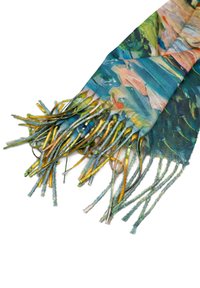 Sciarpa leggera caratterizzata da un vivace motivo floreale in tonalità di blu, verde e giallo, con bordi frangiati per un tocco di texture in più.