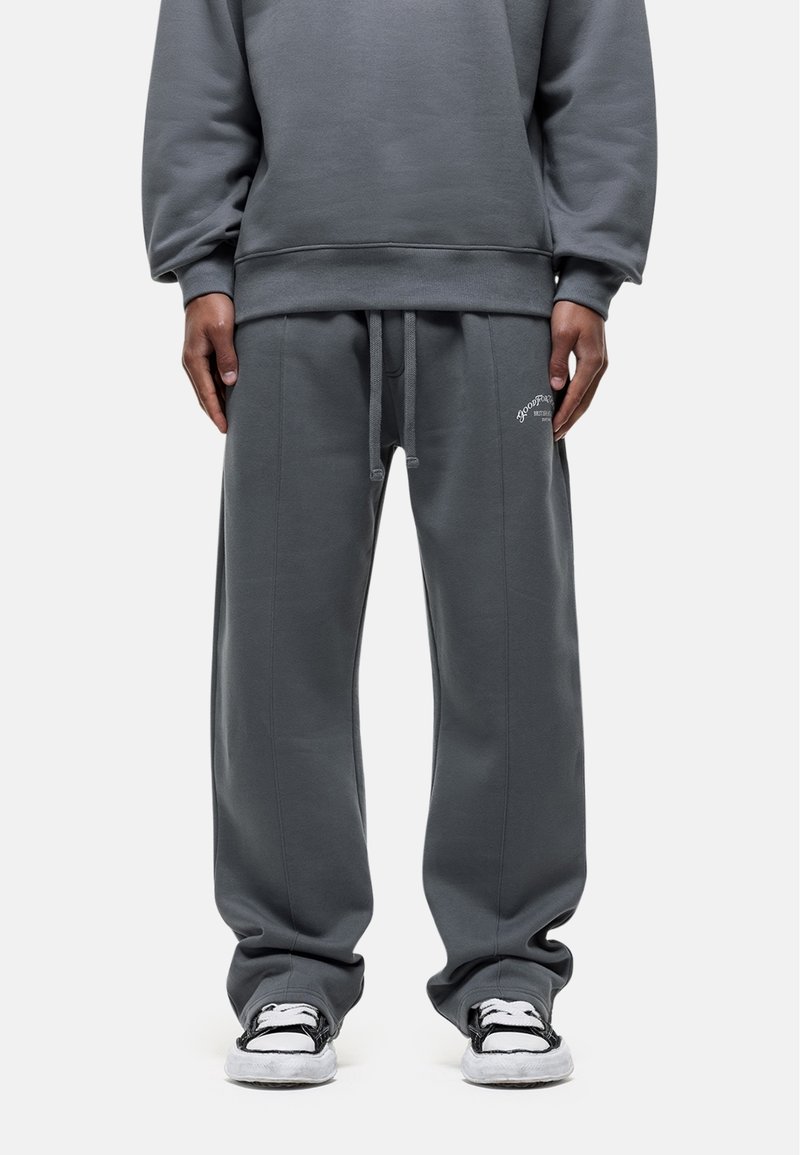 Grijze sweatpants hebben een losse pasvorm, een trekkoord in de taille en subtiele geborduurde logo's. Gemaakt van zachte stof met zijzakken.