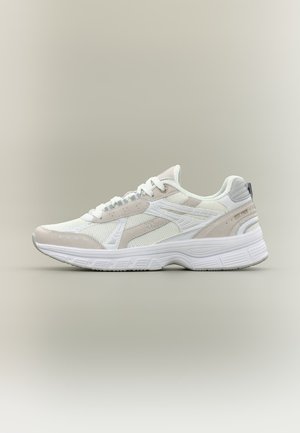Scarpa da ginnastica atletica bianca e beige con pannelli in mesh e suede, suola texturizzata e scritta "EST 1969" sull'area del tallone.