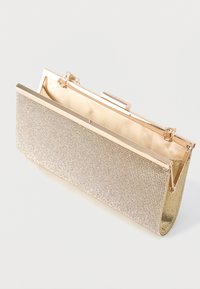Clutch metálico dorado con textura de malla, forma rectangular, herrajes dorados brillantes y cierre clásico de marco. Interior forrado con acabado suave.