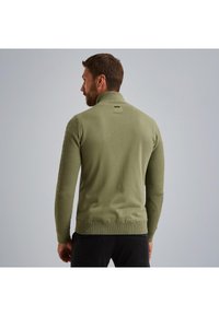 Olivno zeleni pulover s visokim ovratnikom, teksturiranimi stranskimi paneli in rebrastimi mansetami. Gladek material z oprijetim dizajnom.