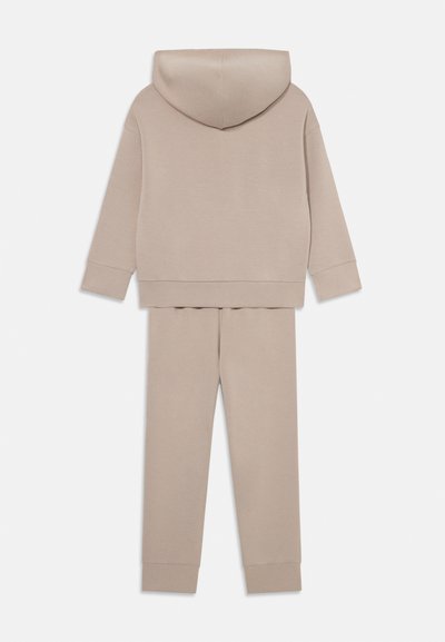 Beige Kapuzenpullover und Jogginghose Set aus weichem Stoff, ausgestattet mit einer Kapuze, langen Ärmeln und elastischen Bündchen an der Hose und den Ärmeln.