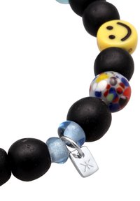 Svart pärlarmband med flerfärgade glaspärlor, en gul smiley-pärla och en silvertagg med en logotyp. Släta och texturerade ytor.