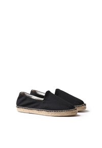 Zwarte canvas espadrilles met elastische zijinvoegen, jute gevlochten zool en witte stiksel details. Platte, afgeronde teenvorm.