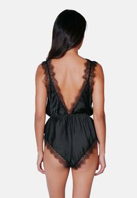 Svart satin bodysuit med djup V-back, spetsdetaljer längs axlarna och bensluten, elastisk midja för en utförlig passform, slät textur.