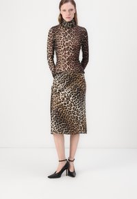 Leopard-print, fitted turtleneck top and mid-length skirt in earthy tones; smooth texture, paired with black high-heel shoes and ankle straps.