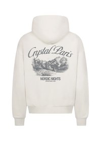 Felpa bianca con cappuccio regolabile. Presenta una grafica grigia di montagne, una baita e la scritta "Crystal Paris Nordic Nights" sul retro.