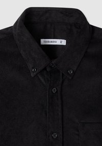 Camicia nera in velluto a coste con colletto abbottonato, tasca frontale e bottoni neri. Etichetta con scritta "TERRANOVA, taglia XL."