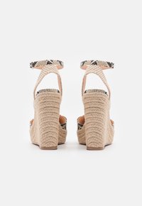 Béžové espadrilky na platformě se tkanou texturou, s kotníkovým páskem se vzorem hadí kůže a strukturovaným podpatkem.