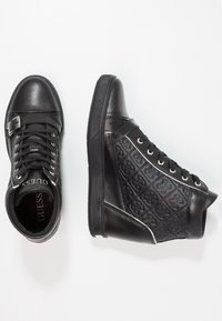 Black leather sneakers featuring a textured design with a logo pattern, featuring a lace-up front, side stitching, and rubber soles.