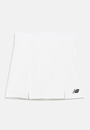 Biela atletická sukňa s malými prednými rozparkami a čiernym logom New Balance na dolnej pravej strane, zobrazená na jednoduchom pozadí.