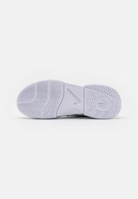Sål av sko med teksturert fiskebeinsmønster, hovedsakelig hvit med subtile grå aksenter. Har et rundt logo og ventilasjonsdetaljer.