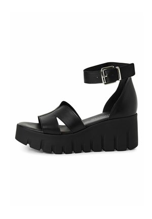 Schwarze Plateausandalen aus glattem Leder mit einem Knöchelriemen, ausgestattet mit einem breiten Frontband und einer strukturierten, klobigen Sohle.