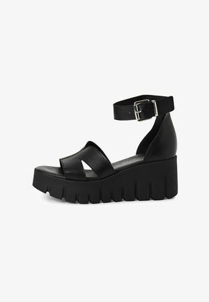 Sorte platformsandaler lavet af glat læder med ankelrem, som har en bred frontrem og en tekstureret, chunky sål.