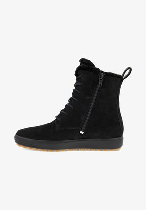 Sort ruskinds ankelstøvle med snørebånd foran, sidelukning med lynlås, blød faux fur-krave og struktureret gummisål med en kontrasterende tan-farvet tread.