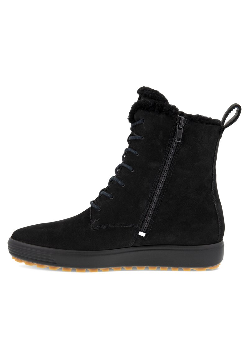 Stivale alla caviglia in suede nero con lacci frontali, cerniera laterale, colletto in morbido pelliccia artificiale e suola in gomma testurizzata con un battistrada in contrasto color tan.