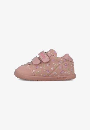 Zapatillas infantiles rosas hechas de material sintético, con patrones florales, dos tiras de velcro, y suela de goma texturizada. Logotipo de la marca visible.
