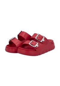 Red rubber slide sandals with two wide straps, silver buckles, and a textured sole. The design features a chunky, cushioned footbed.