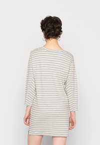 Vestido cinza riscado com um corte descontraído, mangas três quartos, decote redondo e fendas laterais para maior liberdade de movimento. Tecido de textura suave.