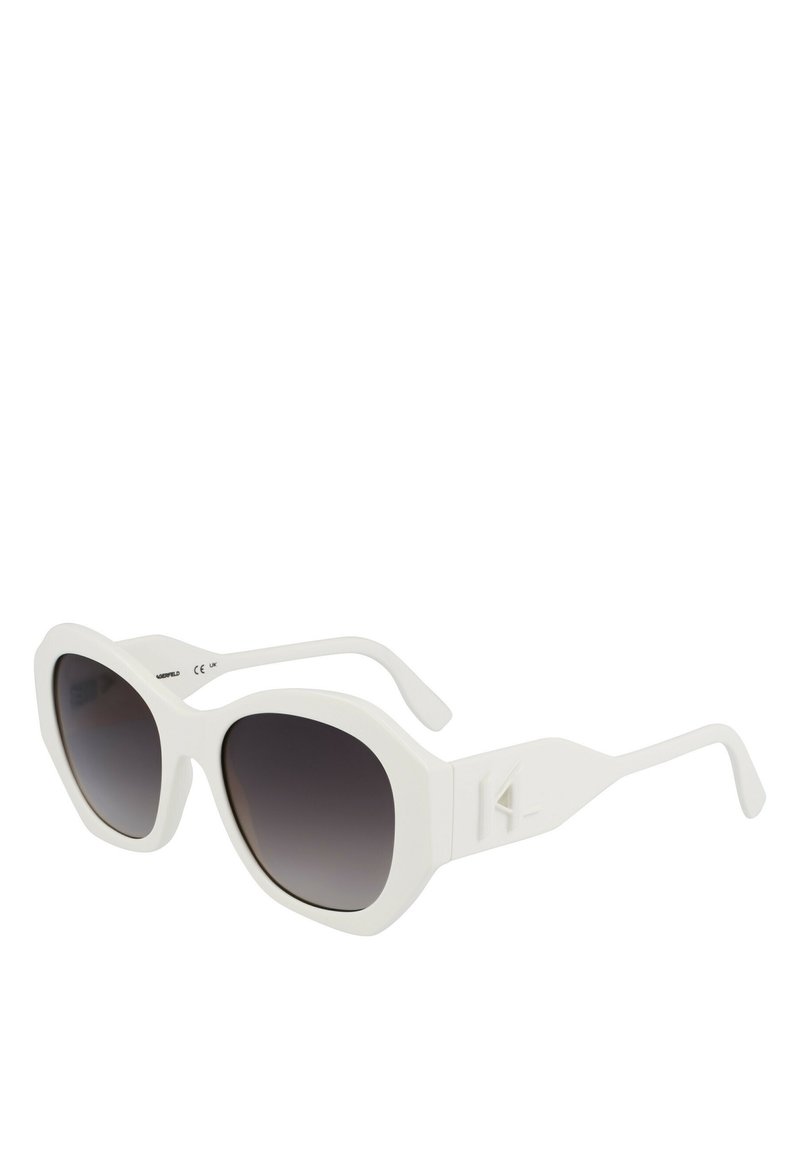 Lunettes de soleil blanches surdimensionnées avec des verres sombres dégradés, des montures épaisses et angulaires, et des branches plates arborant un accent de logo triangulaire.