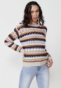 Striped knitted sweater featuring brown, white, and blue patterns, with a ribbed hem and cuffs. Made of a textured yarn. Casual silhouette.