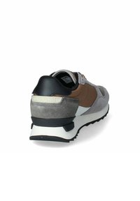 Scarpe sportive con una combinazione di suede grigio, marrone e nero e materiali in rete. Suola intermedia bianca, suola esterna nera texturizzata, logo sul tallone, colletto imbottito.