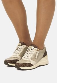 Sneakers con un mix di materiale beige metallico testurizzato e accenti marrone scuro. Design con lacci e dettaglio zip, sole con motivo.