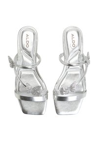 Silver heeled sandals featuring butterfly accents with rhinestones. Strappy design and shiny metallic surface; a modern, open-toe style.