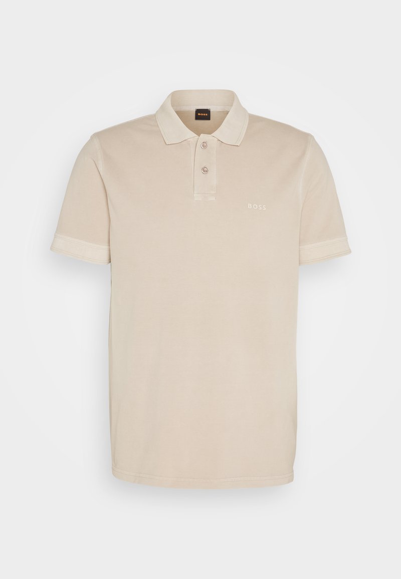 Polo color beige fabricado en suave algodón. Presenta un cuello clásico, dos botones y un pequeño logo bordado en el pecho.