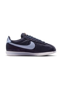 Σκούρο μπλε Nike sneaker χαμηλού προφίλ με ανοιχτό μπλε λογότυπο Swoosh, κορδόνια μπροστά και λευκή ραβδωτή σόλα.