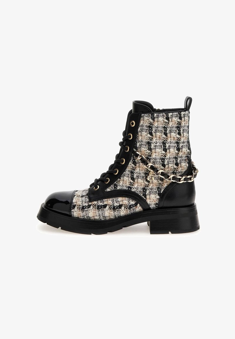 Bottine noire en cuir verni et tweed avec un laçage à l’avant, œillets dorés, semelle épaisse et détail décoratif d’une chaîne dorée sur le côté.