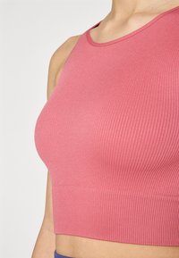 Csíkozott, rövidített tank top puha rózsaszínben, kerek nyakkivágással és széles pántokkal, sima, rugalmas anyagból készült.