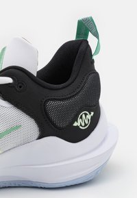 Buty sportowe z czarną siateczką na górze, białą podeszwą środkową i akcentami w kolorze mięty. Posiadają wyściełane pięty oraz wzorzystą pętlę do łatwego zakładania.