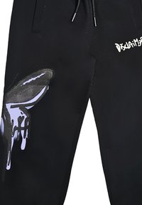 Pantaloni neri con una vestibilità rilassata, caratterizzati da un'illustrazione in stile graffiti viola e testo bianco, realizzati in un tessuto morbido con una leggera lucentezza.
