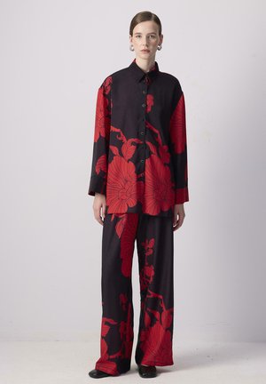 Sort stofoutfit med iøjnefaldende røde blomsterprint, bestående af en langærmet skjorte med knapper og brede bukser, jævn tekstur, afslappet pasform.
