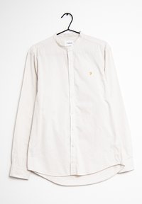 Lichtbeige langekm shirt met een bandkraag, knopen aan de voorkant en een klein goudkleurig logo op de linkerkant van de borst. Gladde katoenstof.