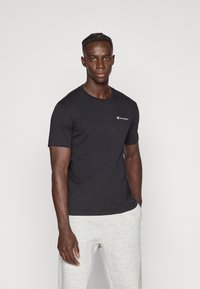 Μαύρο βαμβακερό t-shirt με στρογγυλή λαιμόκοψη και κοντά μανίκια, με λευκό λογότυπο Champion στο αριστερό στήθος. Απλός, εφαρμοστός σχεδιασμός.